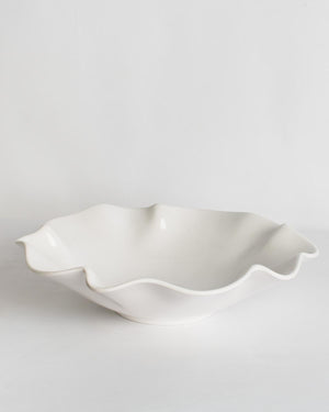 White melamine bowl with wavy edge on a light gray background