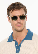 Man in a polo wearing tortoiseshell double-bridge sunglasses