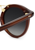 Close-up of the espresso round sunglasses' gold rivet detail