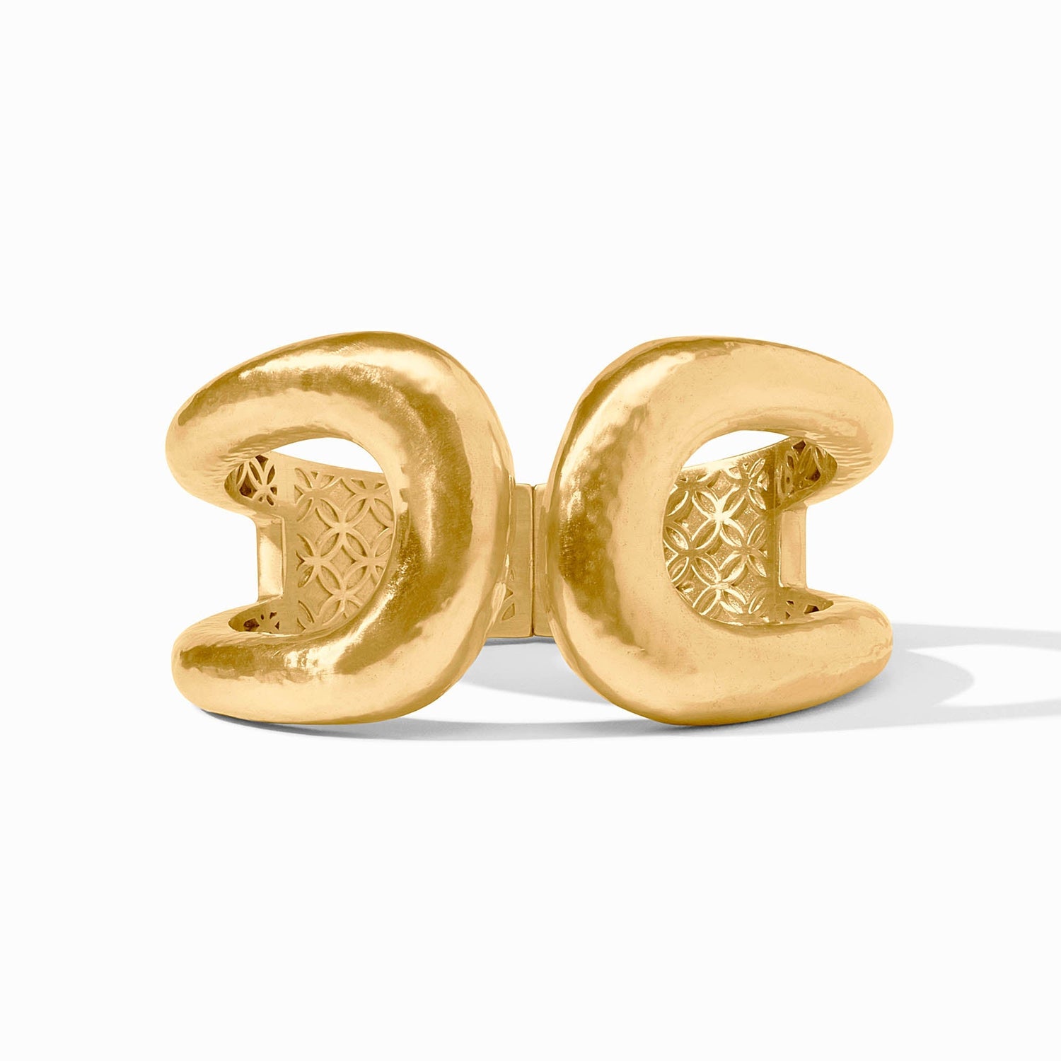 Gold cuff bracelet with a hammered texture and geometric pattern interior