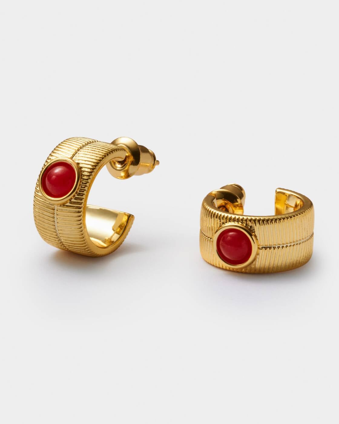 Gold hoop earrings with textured finish and central red stone