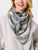 Smiling woman wearing a gray striped scarf knotted at the neck