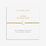 Gold bead bracelet with a central clover shaped pearl on a display card