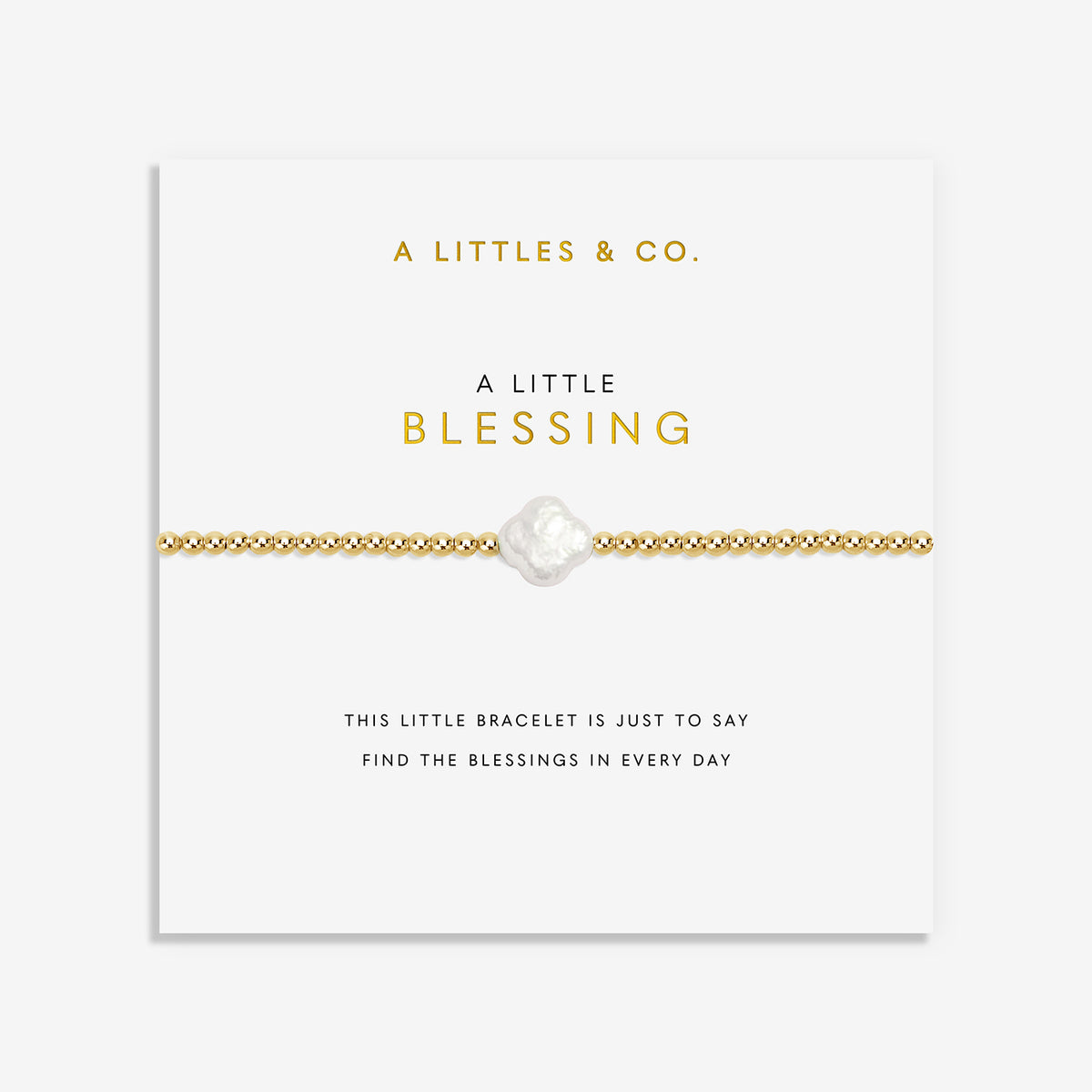 Gold bead bracelet with a central clover shaped pearl on a display card