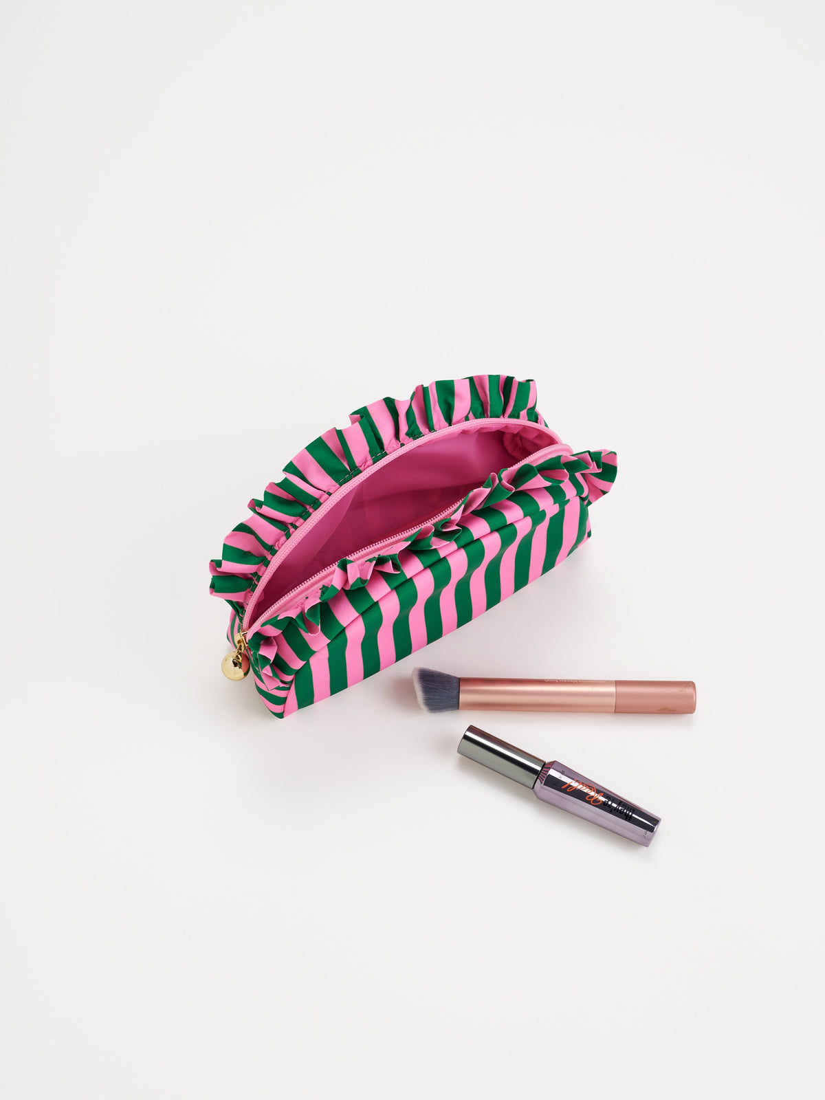 Striped ruffle zip pouch with a pink lining and makeup