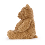 Side profile of a fluffy brown teddy bear sitting