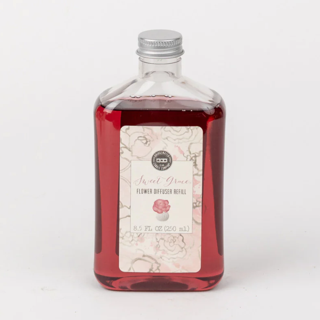 A clear glass bottle with a label that reads 'Sweet Grace Flower Diffuser Oil', containing red-colored oil.