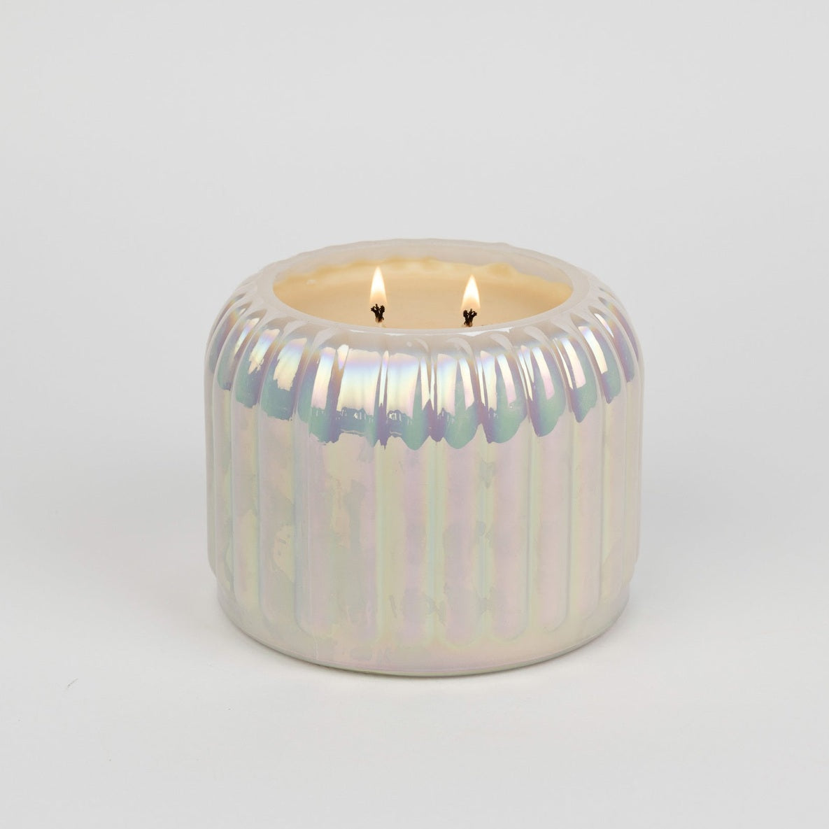 Iridescent candle holder with a candle on a light gray background
