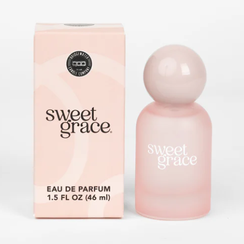A frosted pink bottle of Sweet Grace Eau de Parfum with a glossy pink ball top, next to its pink box packaging.