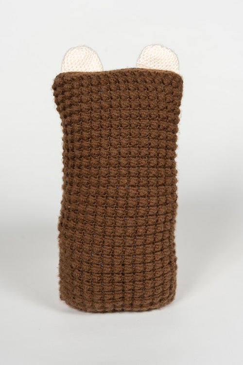Knitted brown textured cylindrical object with two small white rounded ears on a white background
