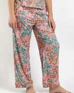 Person wearing pink floral print pajama pants with orange trim