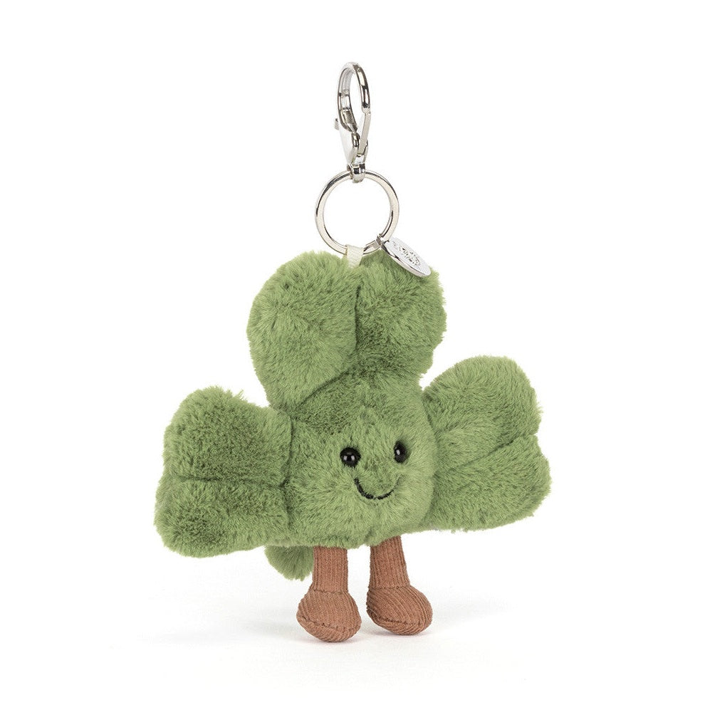 Plush keychain shaped like a green clover with a smiling face on a white background