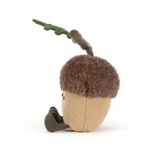 Side view of a stuffed toy acorn with a branch on a white background