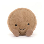 Tan plush macaron with a smiling face and brown corduroy feet, front view