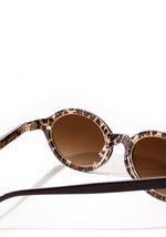 Close-up of oval brown sunglasses with a leopard print interior