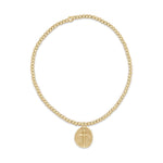 Gold beaded stretch bracelet with a round pendant featuring a cross