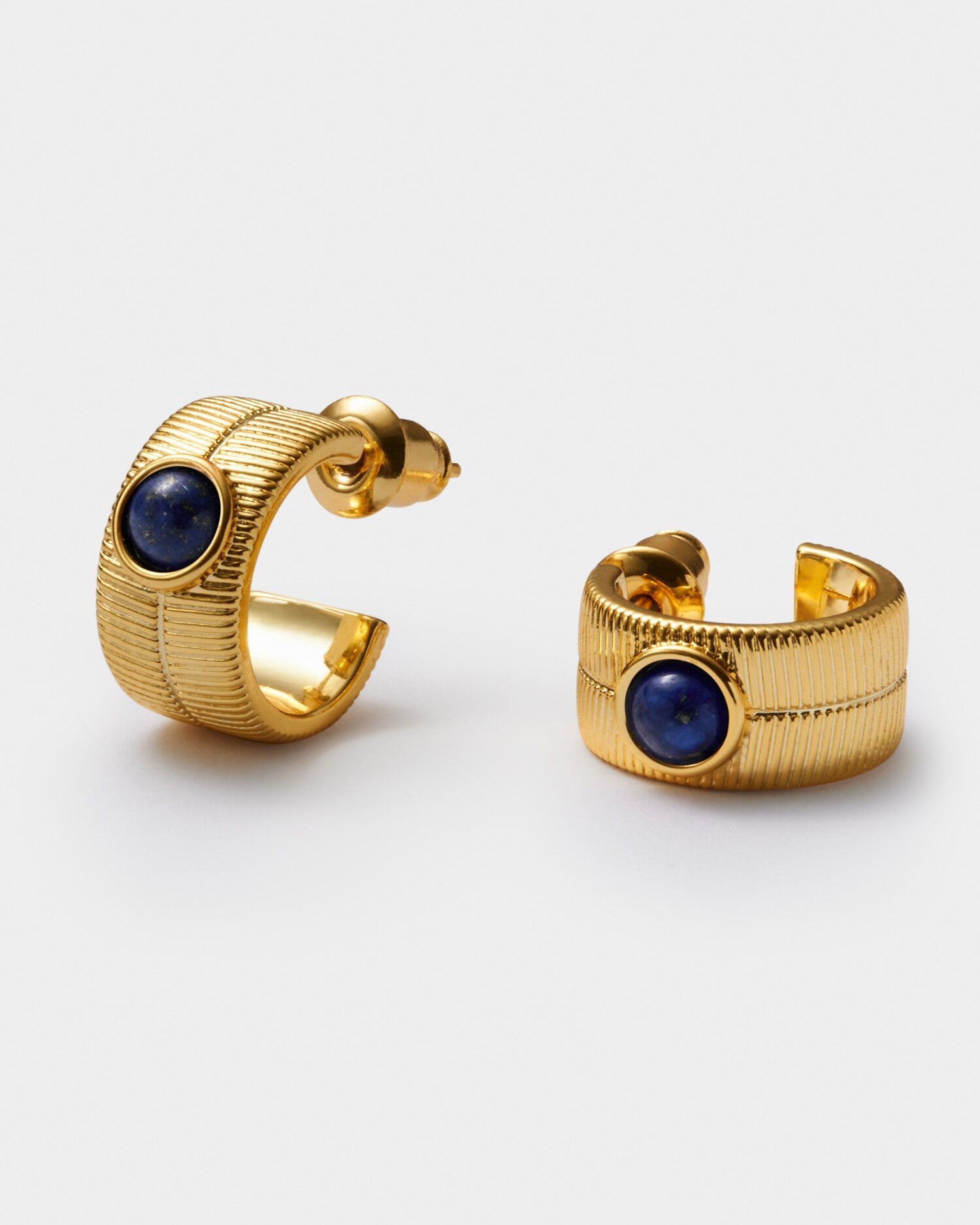 Gold hoop earrings with textured ribbed detail and a central round blue lapis lazuli gemstone