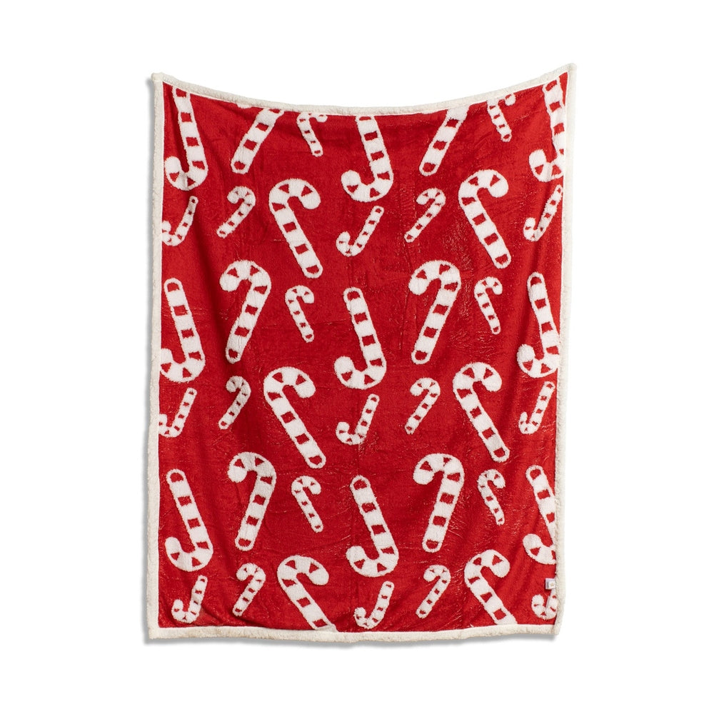 Red throw blanket with white candy cane pattern and white sherpa trim
