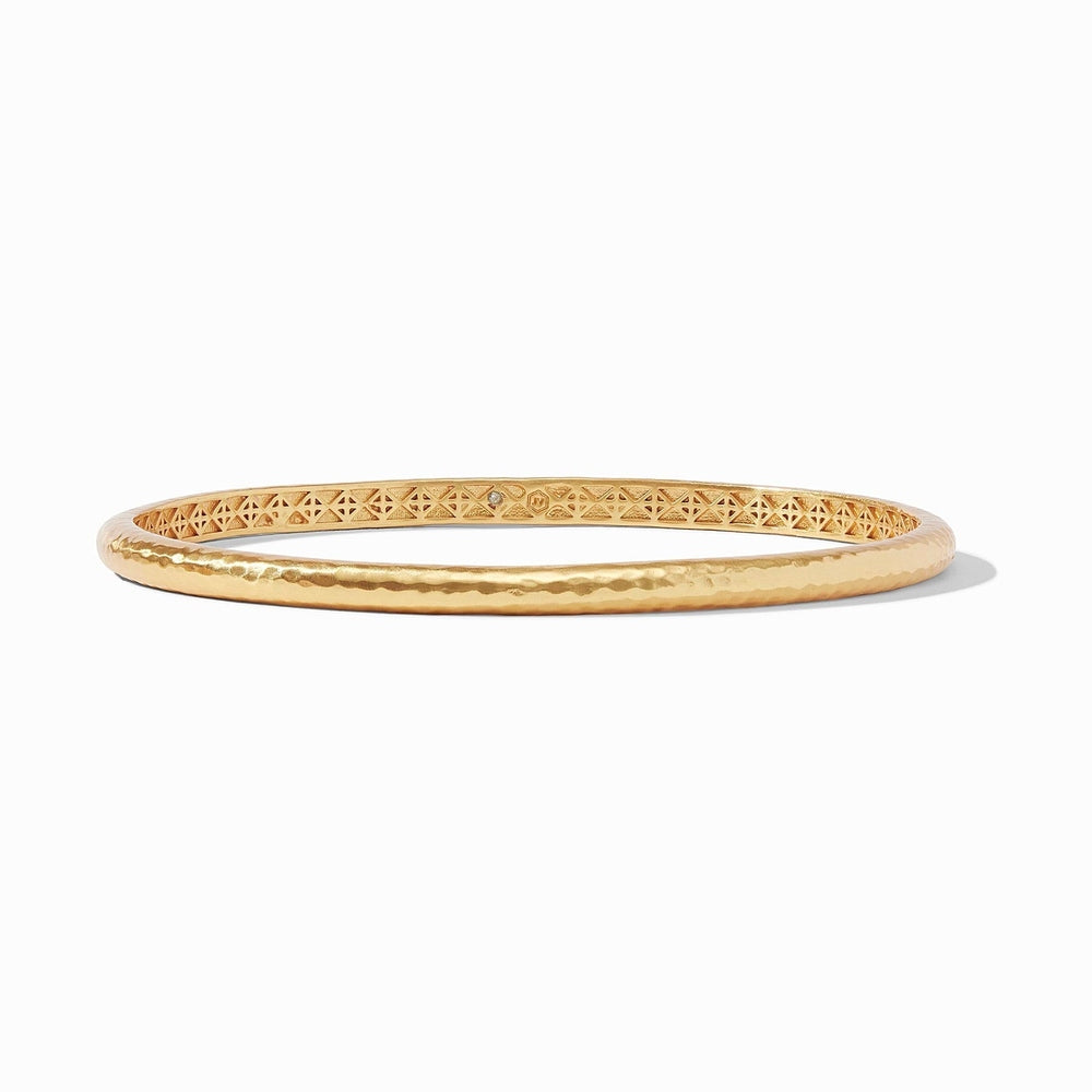 Gold bangle bracelet with hammered texture and geometric interior pattern