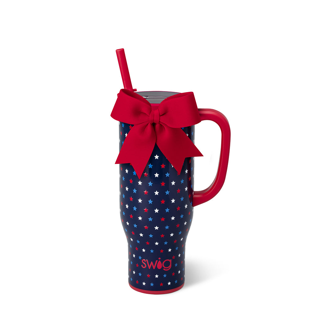 Blue mug with star pattern and red handle, featuring a red bow and straw on a white background.