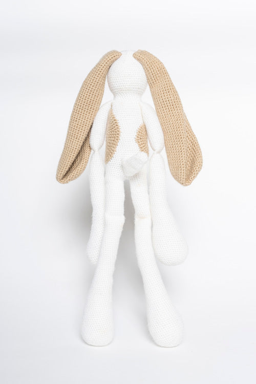 Crocheted textile, anonymous artist, white and tan spotted bunny doll featuring long floppy ears and slender limbs against a white background