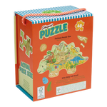 Printed cardboard packaging by Floss & Rock featuring a 60-piece dinosaur-shaped puzzle illustrated with prehistoric creatures in a jungle landscape including a vibrant orange-and-white striped rope handle and shimmering foil accents