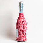 Bottle wrapped in red paper with 'XO' pattern on a white background