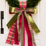 Bow of olive velvet, magenta velvet, pink and green plaid and woven trim ribbons on a boxwood wreath