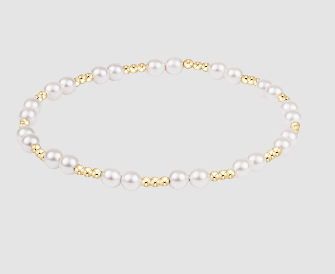 Pearl bracelet with gold accents on a light gray background