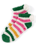 Photograph of a pair of plush striped ankle socks on a white background featuring vibrant pink and yellow stripes, soft white pom-poms on the heels, and colorful non-slip grip beads on the soles