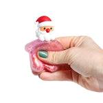 Hand squeezing a pink glitter squishy toy with a Santa head