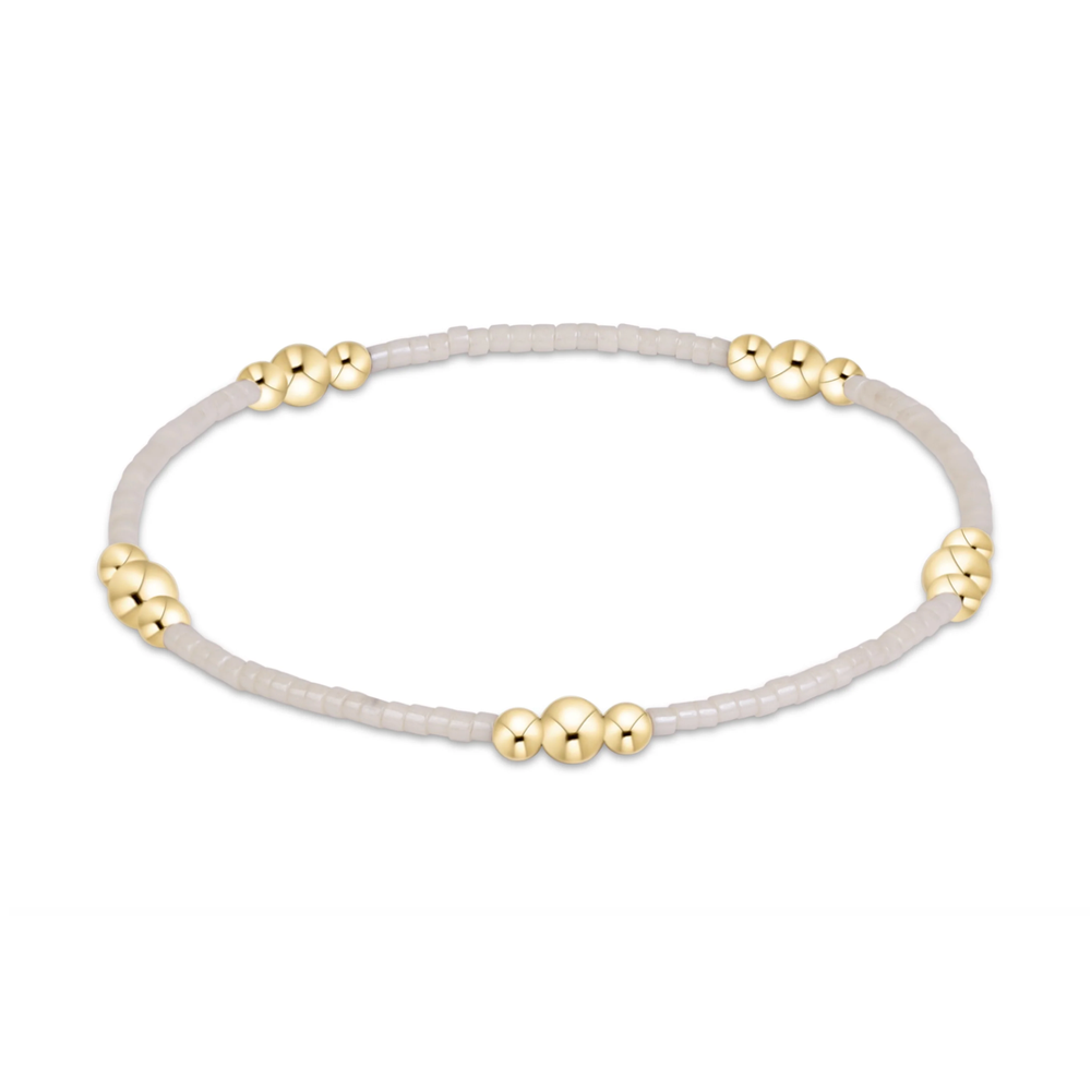 White seed bead stretch bracelet with gold bead clusters