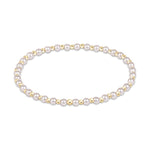 Stretch bracelet with alternating white pearls and small gold beads