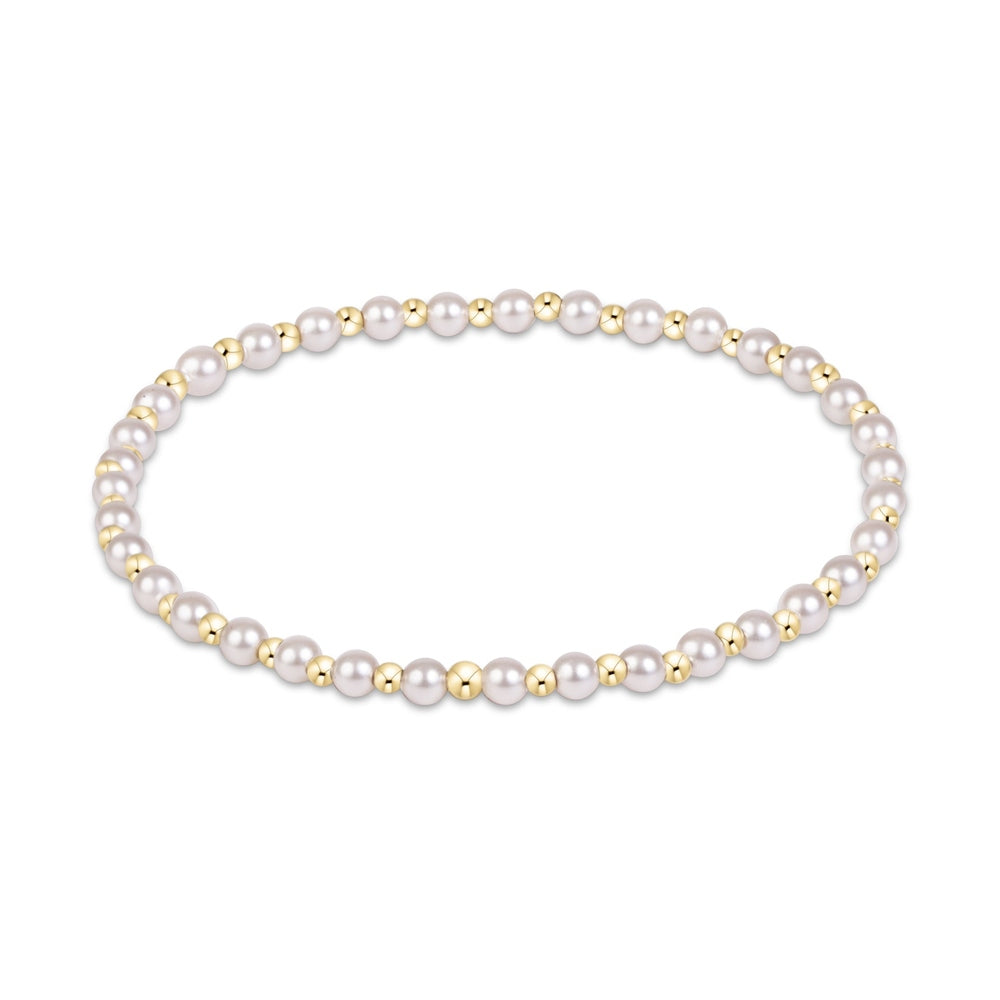 Stretch bracelet with alternating white pearls and small gold beads