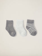 a white sock, grey sock, and white and grey striped sock on a taupe background