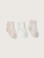 a pink sock, a white sock, and a pink and white striped sock on a light taupe background