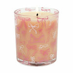 Candle in a glass jar with pink and white bow pattern on a white background