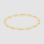 Gold beaded bracelet on a light gray background