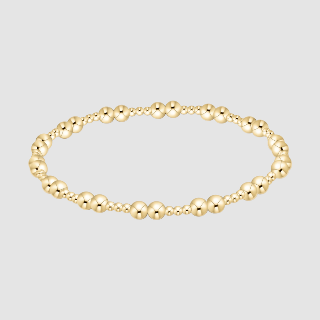 Gold beaded bracelet on a light gray background