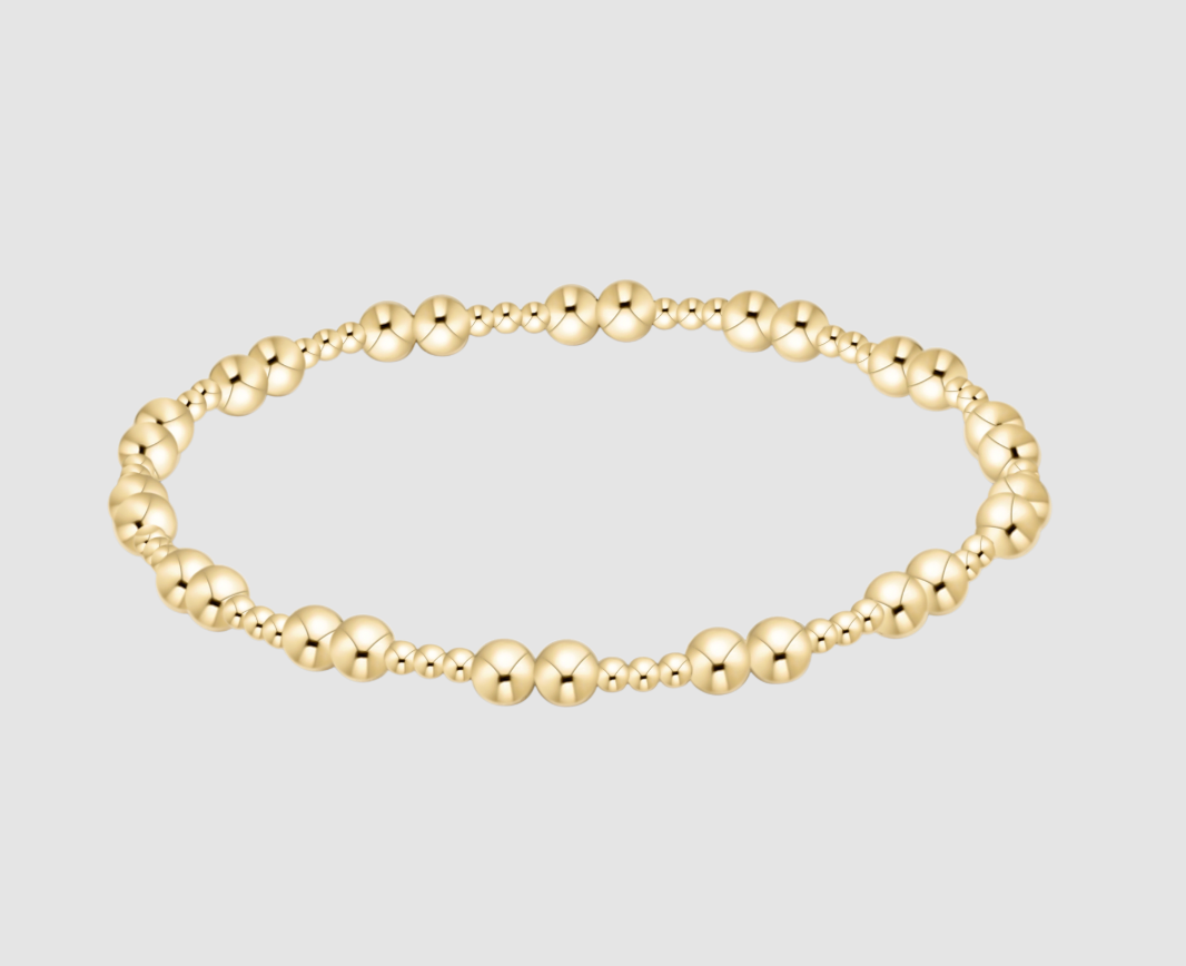 Gold beaded bracelet on a light gray background