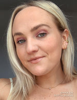 Blonde woman wearing pink eyeshadow and gold jewelry