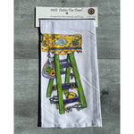 Tea towel with a purple, green and gold ladder in its package
