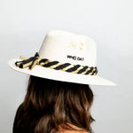 A person wearing a white hat with 'Who Dat' text and a black and yellow striped pattern on the brim.