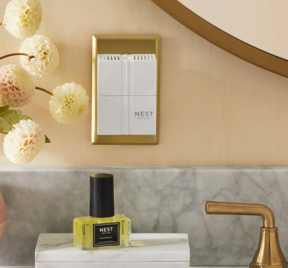 Nest New York wall diffuser and grapefruit fragrance refill bottle on a marble counter