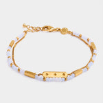 Gold chain bracelet with light blue beads and a central rectangular charm featuring three star engravings