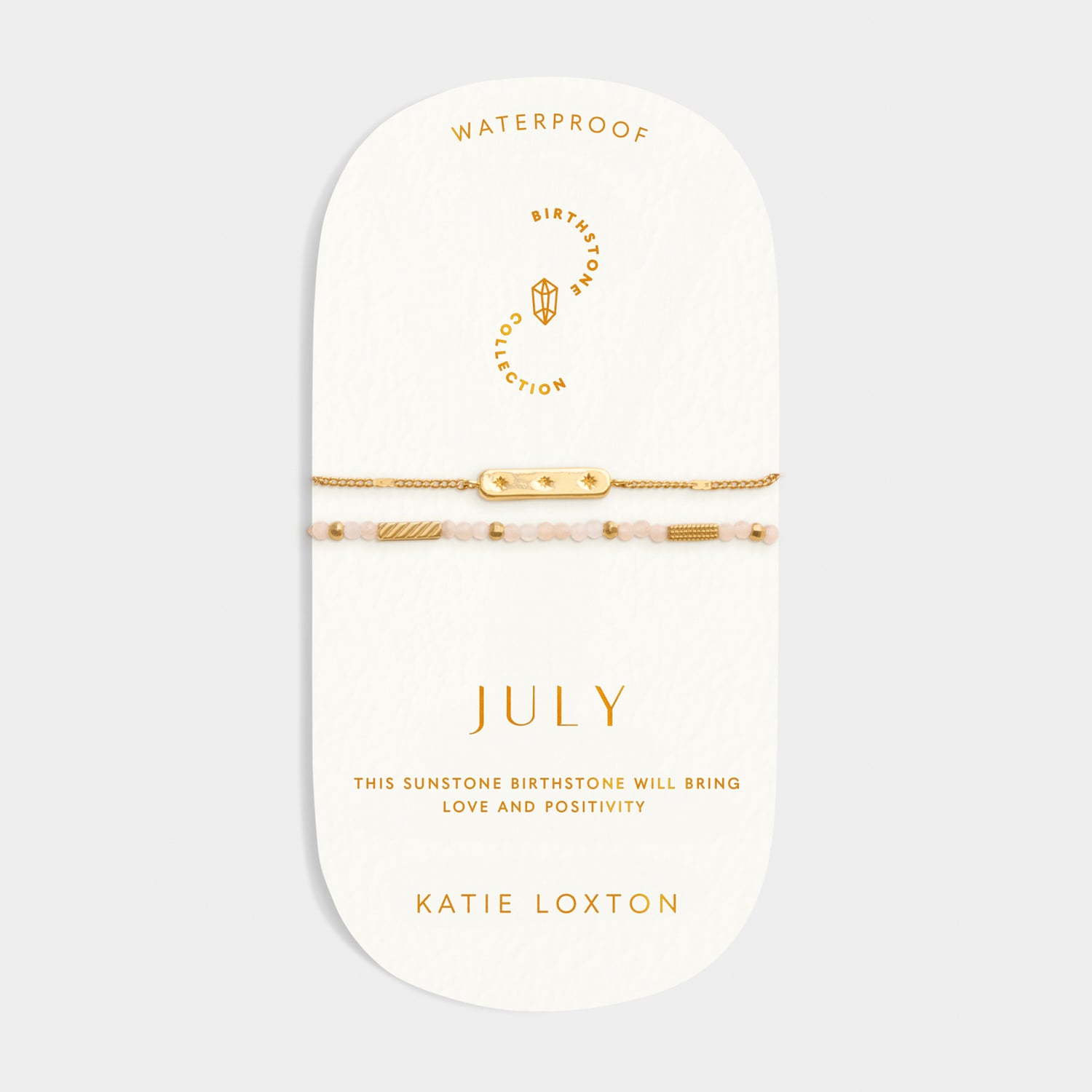 Gold chain bracelet and beaded sunstone bracelet on a branded display card labeled July