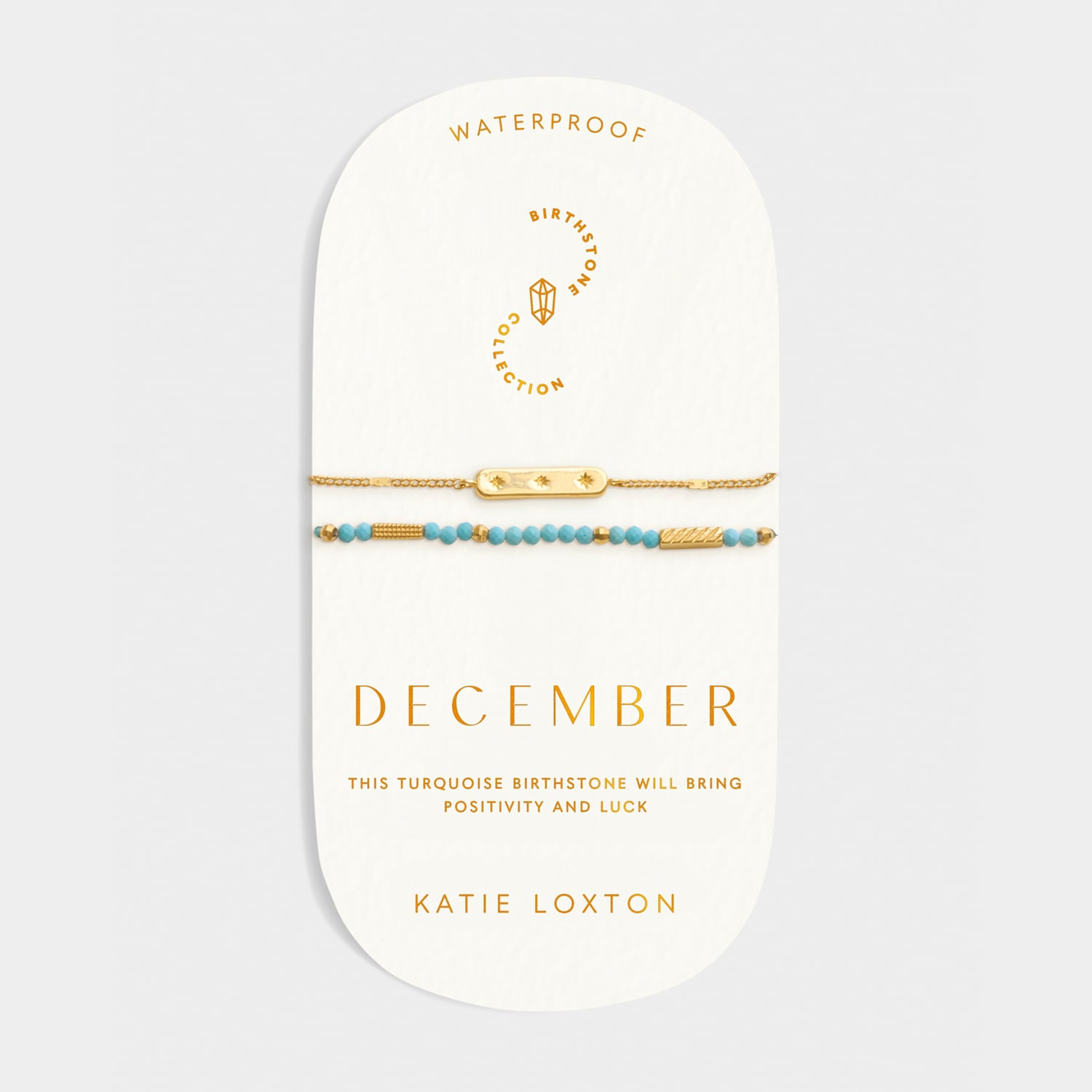Two gold bracelets with turquoise beads on a December birthstone collection display card
