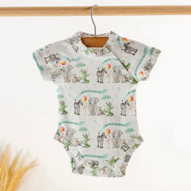 Baby onesie with zoo animal pattern on a hanger against a white background