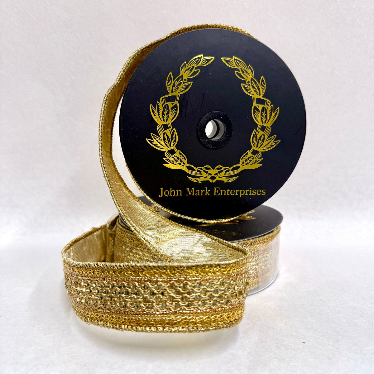Spool of gold metallic ribbon with a jeweled center trim