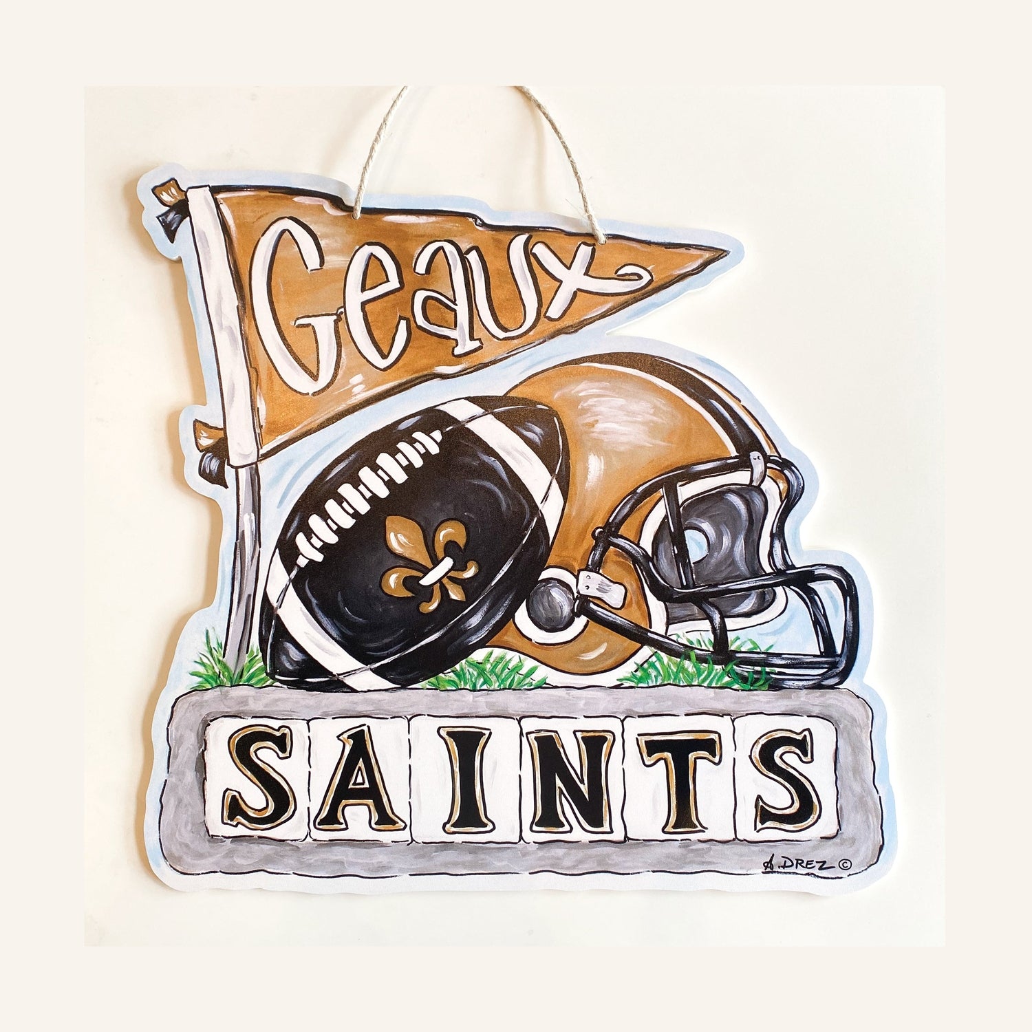 Decorative sign with football, helmet, and 'Geaux Saints' text on a white background